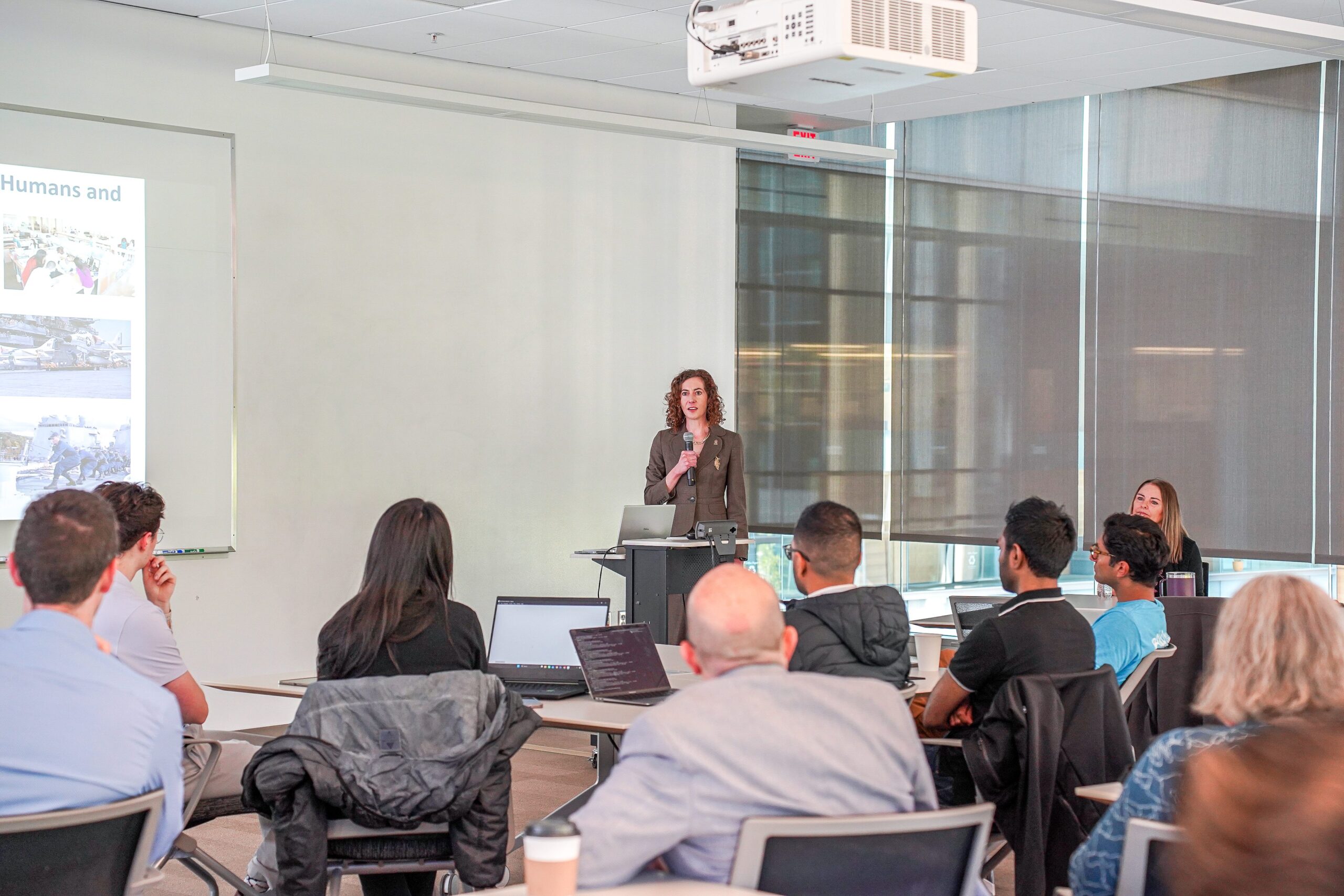 person addresses a large group in an open room