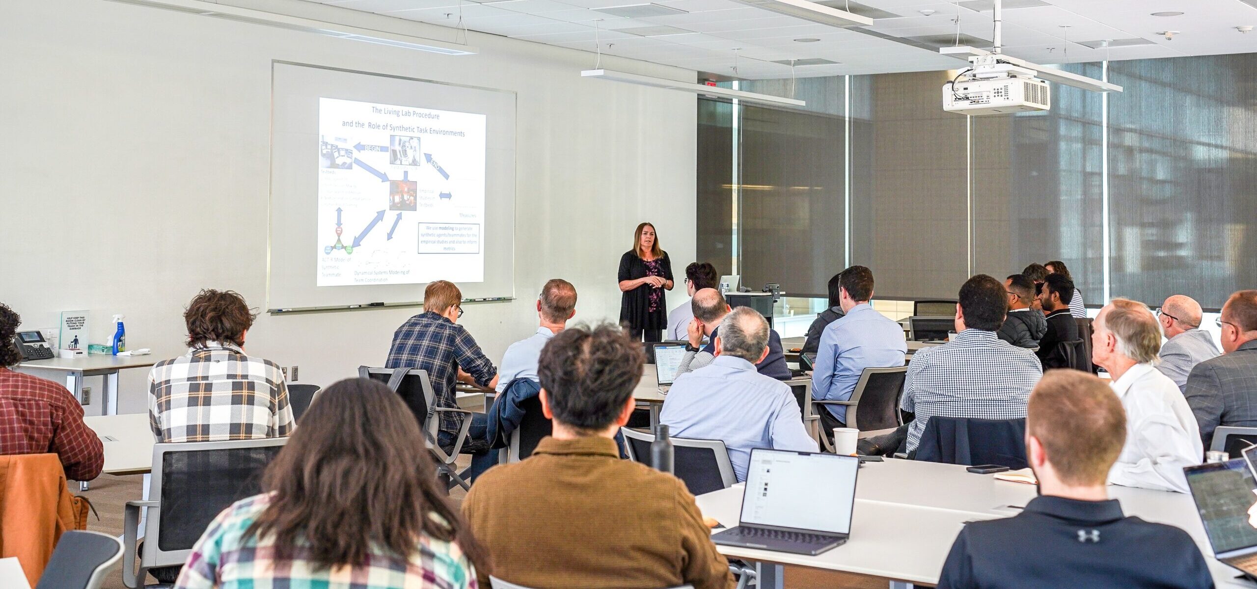 person giving an academic talk to a room full of people