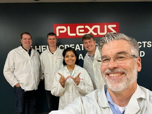 Five people pose for a selfie in white safety jackets