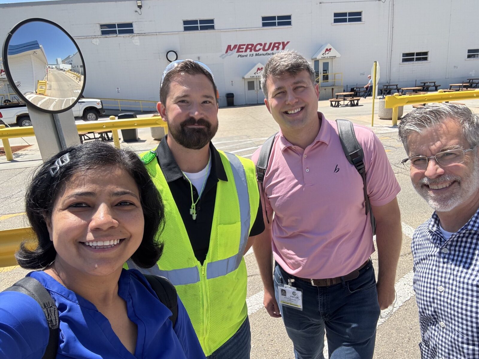 four people pose for a selfie in a construction yard